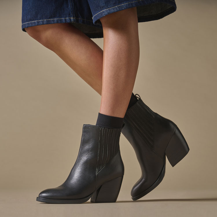 A woman wearing the Shaila heeled chelsea boot in black.