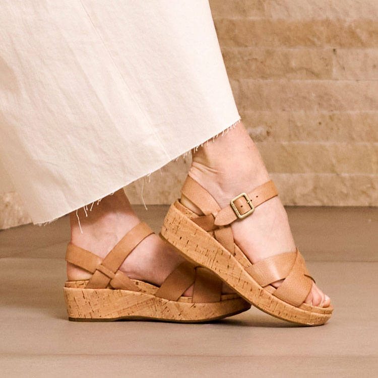 A woman wearing the Myrna 2.0 platform cork sandal in Golden Sand (tan). Shop Myrna.