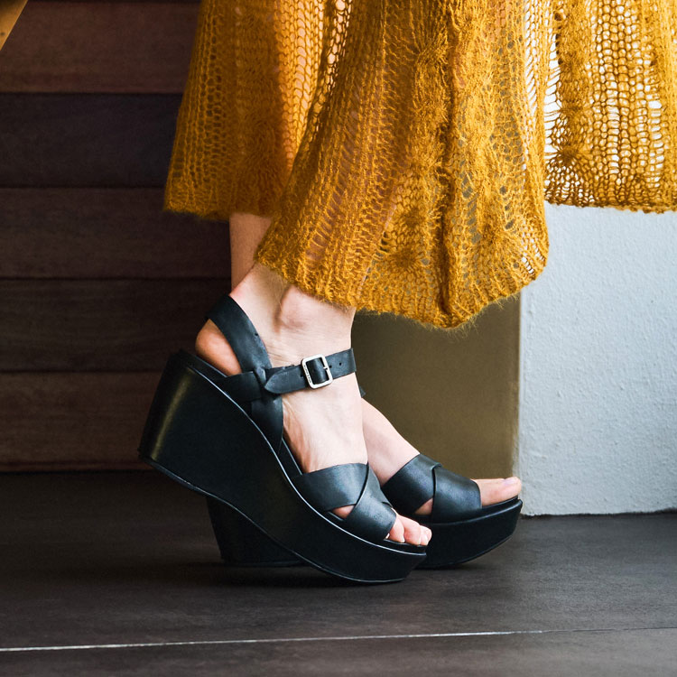 A woman wearing the Ava 2.0 platform sandal in black. Shop Ava 2.0